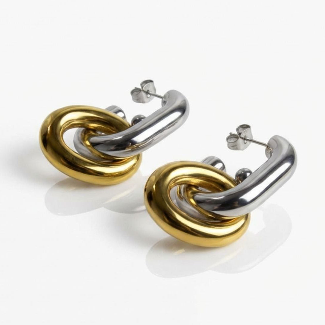 Pair of gold and silver earrings on a white background