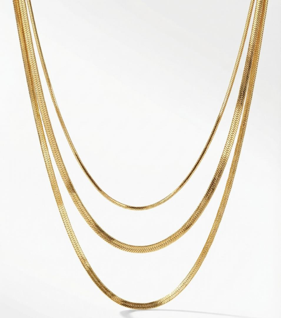 Three gold chains stacked on a white background