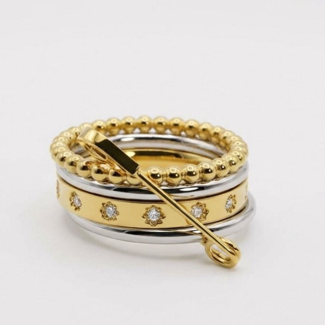 Three gold rings with different designs on a white background