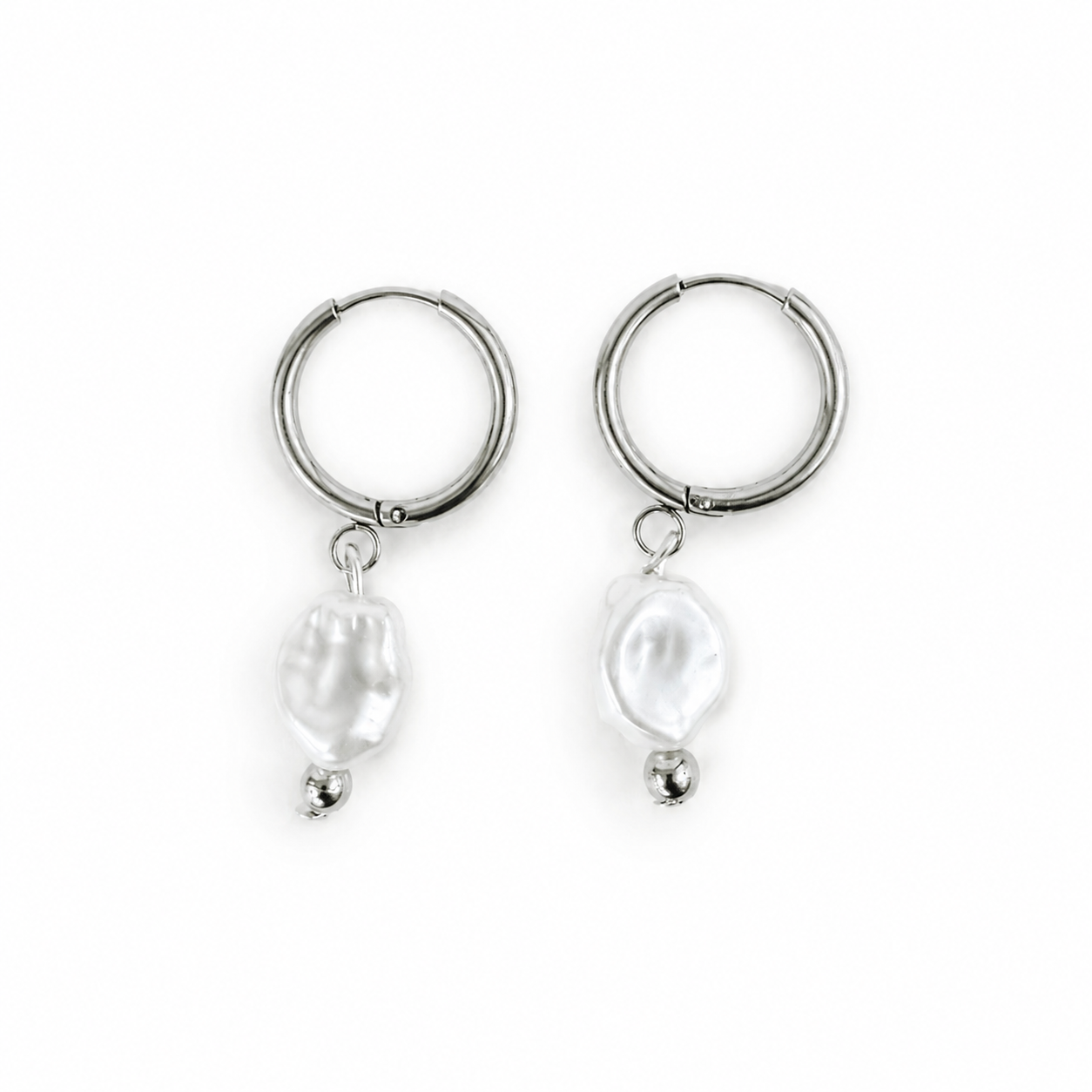 A pair of silver hoop earrings with dangling irregular white baroque pearls and small silver beads at the bottom, shown on a plain white background.