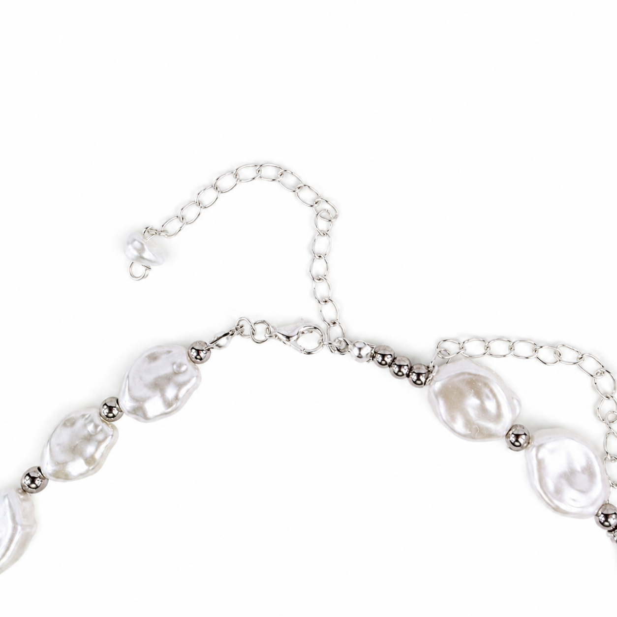 A close-up of a silver-toned chain necklace featuring irregular, lustrous white baroque pearls and small metallic spacer beads, shown on a plain white background.