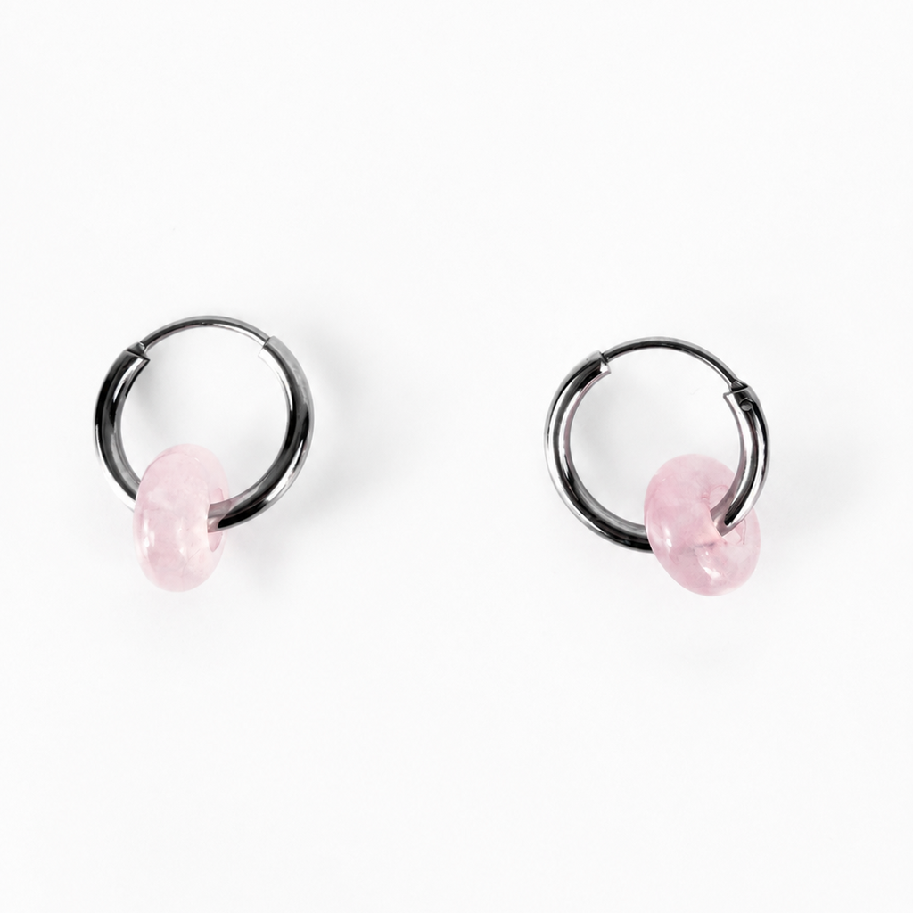 A pair of black metal hoop earrings with small, faceted light pink stone charms, displayed on a clean white background.