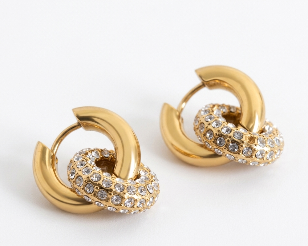 Gold hoop earrings with embedded crystals on a white background