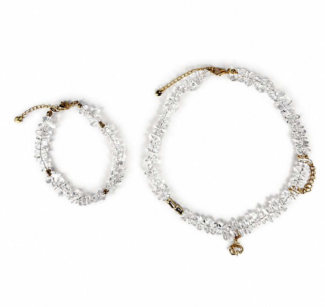 A pair of clear crystal beaded bracelets with gold-toned chain details, displayed on a clean white background.