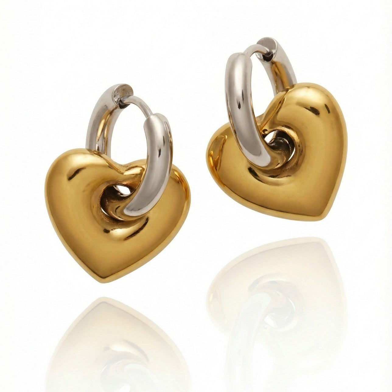 Gold and silver heart-shaped hoop earrings on a white background