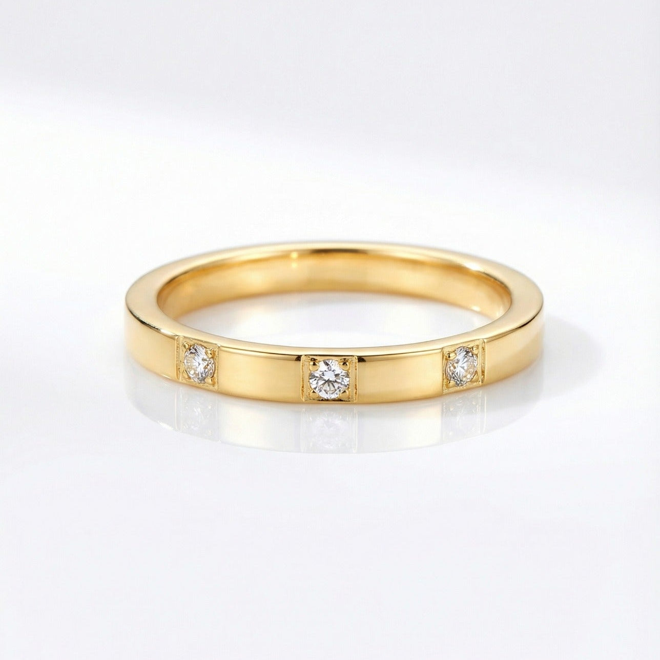 Gold ring with embedded diamonds on a white background
