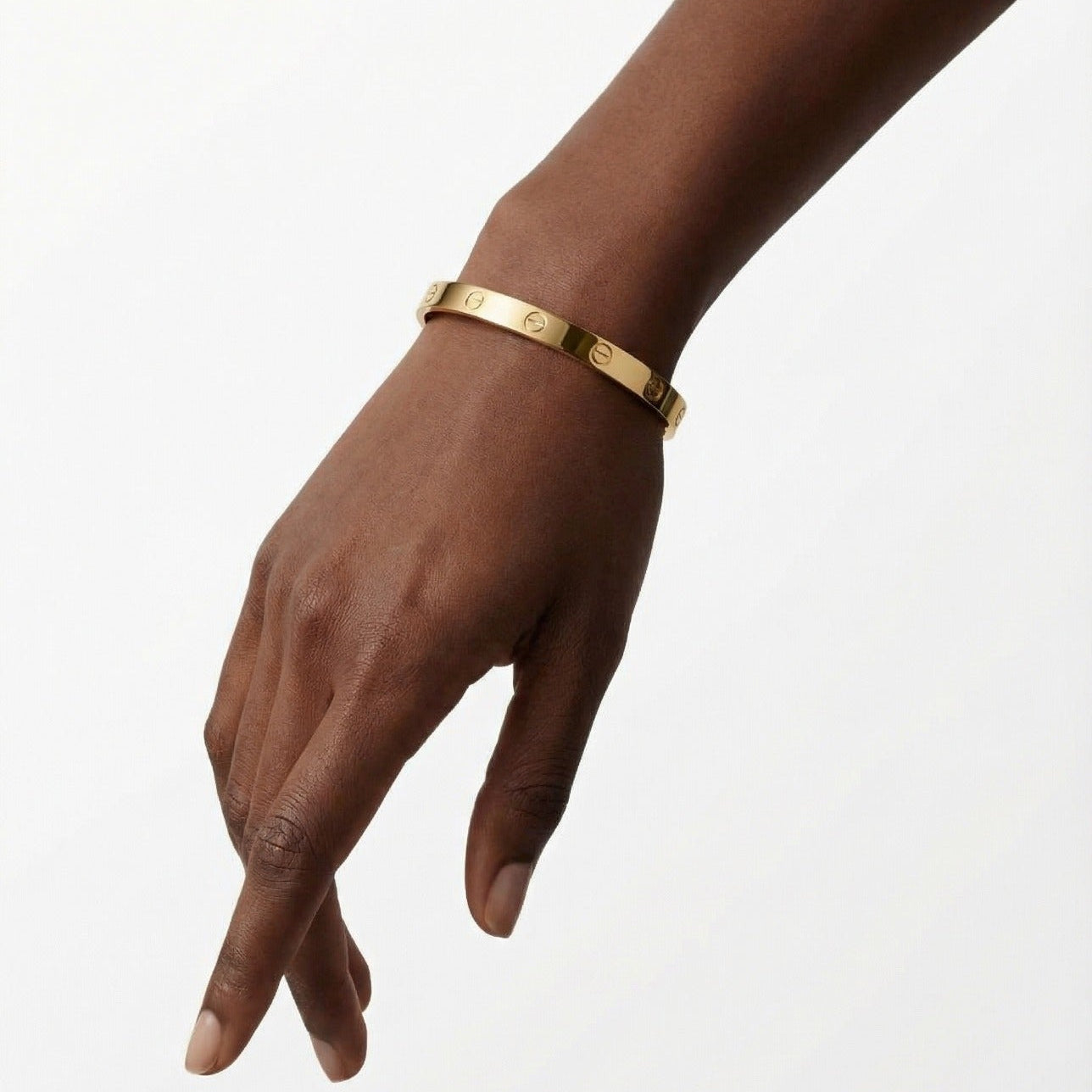 Gold bracelet on a hand against a white background