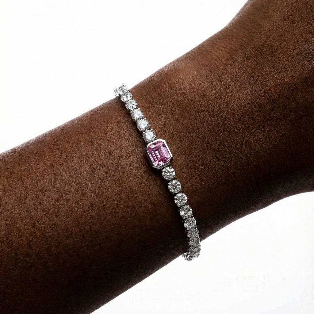 Bracelet with a pink gemstone on a wrist against a white background