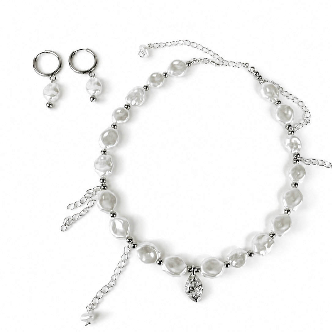 A silver-toned jewelry set featuring a beaded necklace with irregular white pearl-like beads, matching drop earrings, and a small dangling charm, displayed on a clean white background.