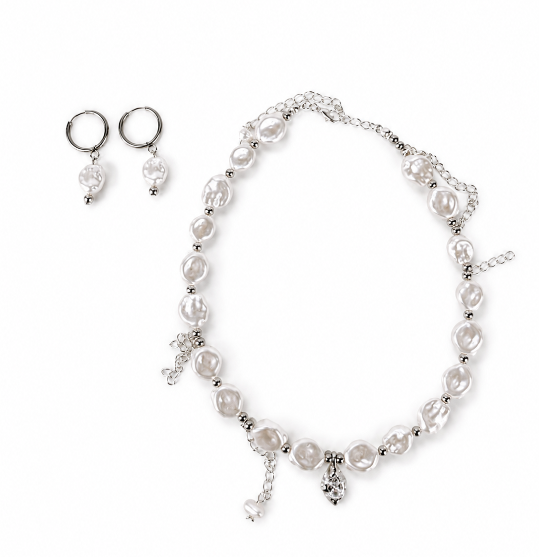 A silver jewelry set featuring a pearl beaded necklace with a central charm, matching drop earrings, and small hoop earrings, displayed on a clean white background.