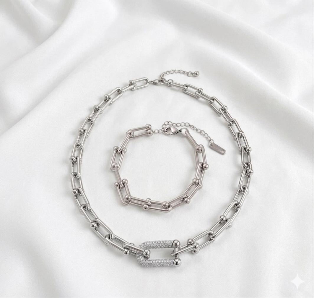 Silver chain necklace and bracelet set on a satin surface