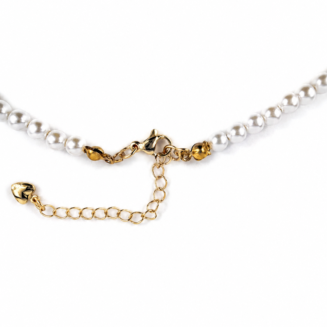 Close-up of a pearl necklace with a gold lobster clasp, extender chain, and decorative gold links on a white background.