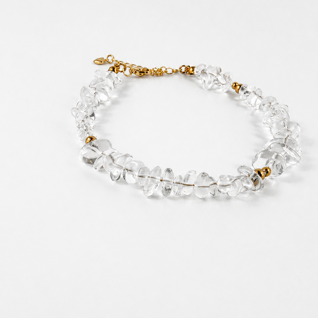 A clear crystal and glass chip beaded necklace with small gold spacer beads and a gold clasp, displayed on a clean white background.